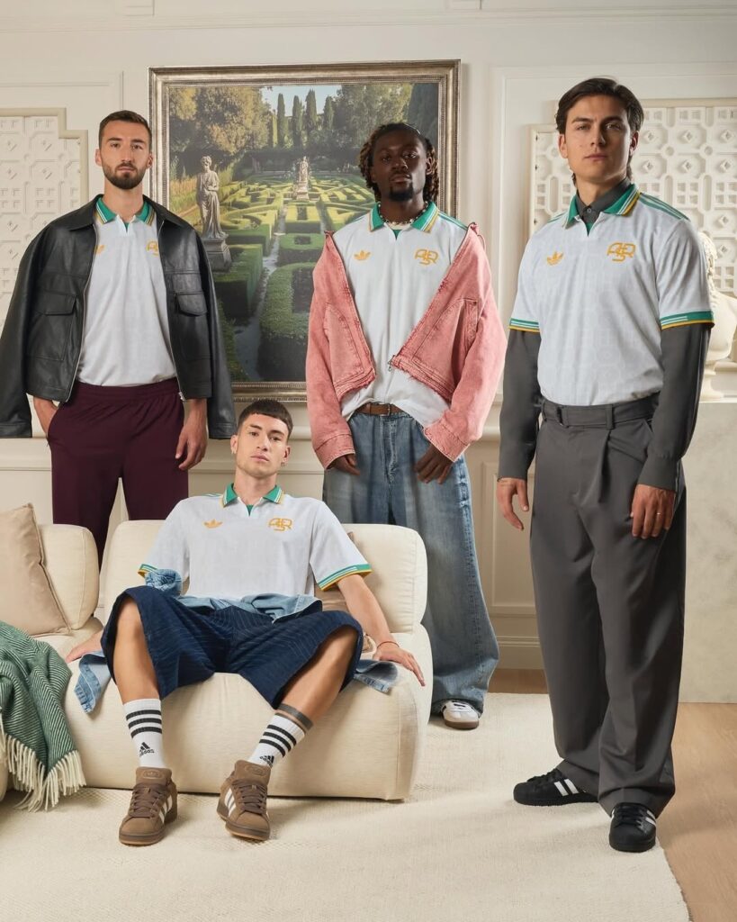 Four As Roma players including Paolo Dybala posing in a fancy room while wearing the new white, teal and gold AS Roma 3rd kit.